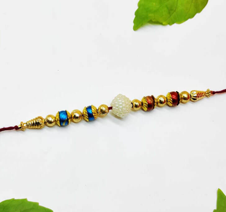 Buy Golden Beads White Pearl Center Piece Bhaiya Rakhi