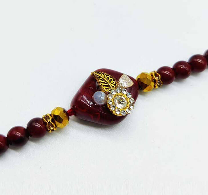 Buy White Diamond Maroon Designer Beads Bhaiya Rakhi